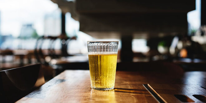 um copo de cerveja em uma bancada de bar